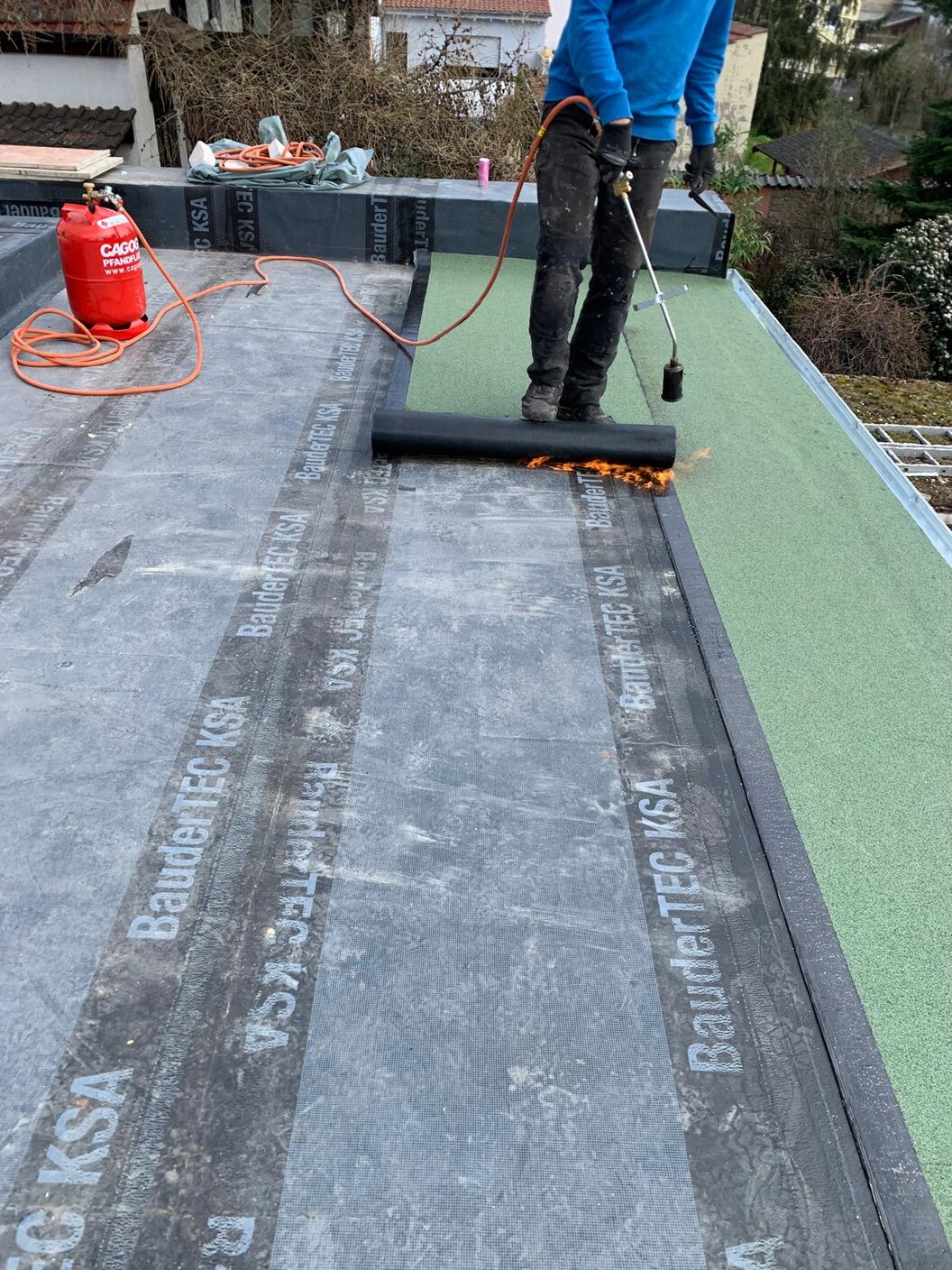 Kunststoffbahn wird auf Flachdach verlegt